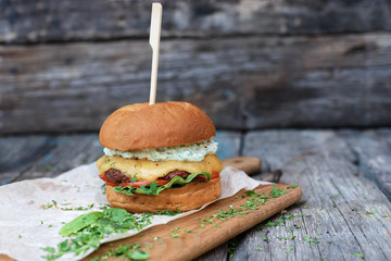 Homemade burger closeup on wooden background with copy space. Selective focus.
