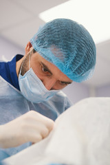 Doctor surgeon looking at a patient in operating theater