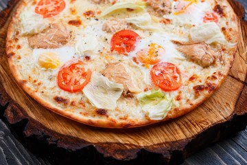 Delicious caesar pizza with cherry tomatoes, grilled chicken, lettuce and quail eggs. Food background, pizzeria concept