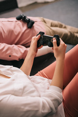 cropped shot of woman with manikin near by playing video game at home, loneliness concept
