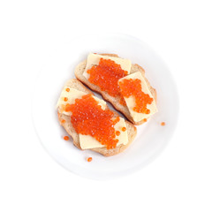 Two sandwiches with butter and red salmon caviar on white bread lies on a round plate, isolated on white background top view