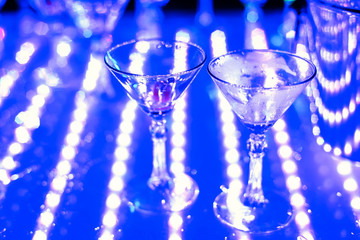 empty Martini glasses at night club at party with focus in the foreground