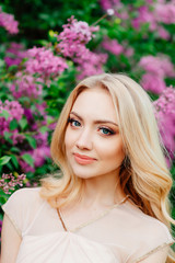 attractive look of beautiful blonde girl, spring photo shoot in flower garden, charming model in spring dress, young woman in spring