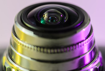 Fototapeta na wymiar Camera lens close - up backlit yellow-purple. Horizontal photo.