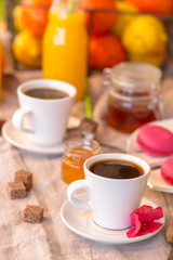 Breakfast with coffee cups, orange juice, makaron the outdoor terrace