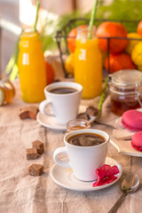 Breakfast with coffee cups, orange juice, makaron the outdoor terrace