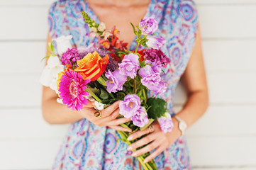 Simple and beautiful bouquet of mixed flowers holding by a young girl