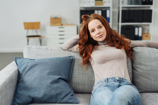 Young woman sitting on comfortable sofa