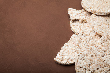Diet rice cakes on brown background, copy space for text.