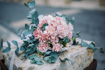 wedding bouquet lies on a stone