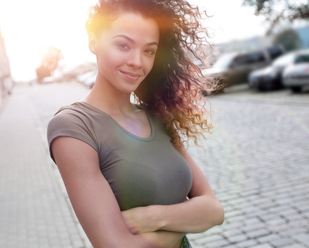 Young woman with afro hairstyle smiling in urban background