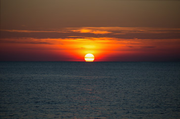 A beautiful sun setting on the horizon on the sea