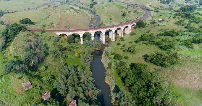 Seven arch rail bridge straddles Elands river near Waterval Boven South Africa 4K aerial