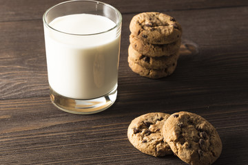  A glass of milk and cookies on a dark wooden background