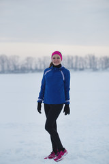 Fototapeta na wymiar Portrait of a smiling young female sportswoman in winter ice field