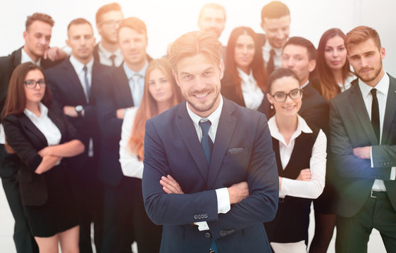 smiling businessman standing on background of her business team.