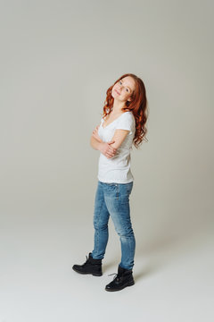 Trendy young redhead woman in jeans and boots