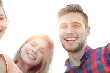closeup of three young people smiling on white background