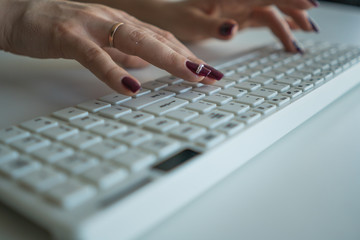 Beautiful female hands on a computer keyboard close-up