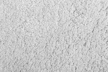 Close-up of shaggy carpet texture background viewed from above in black and white.