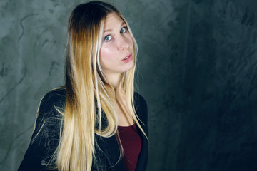 Fototapeta premium Attractive pretty young model posing against a dark studio background with copy space looking. Atomic blonde woman. Fashion style