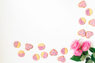 Gingerbread cookie with pink glaze and roses flower on white background. Flat lay. Top view. Woman day background