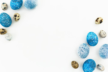 Fototapeta na wymiar Frame made of blue speckled easter eggs and quail eggs with copy space isolated on white background. Flat lay, top view