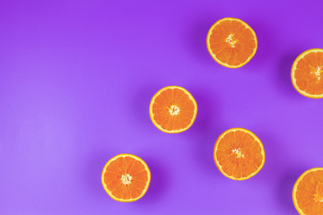 Fresh orange slices on violet background