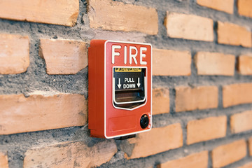 Obraz premium Close up fire alarm activation box on brick wall in room