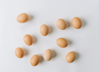 brown eggs scattered on white background