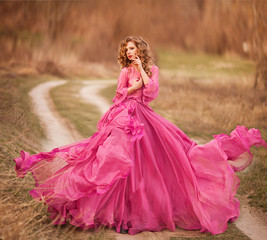 Fototapeta premium Portrait of sexy young beautiful caucasian blonde in pink dress on white background