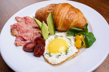 Fresh croissant with ham and salad