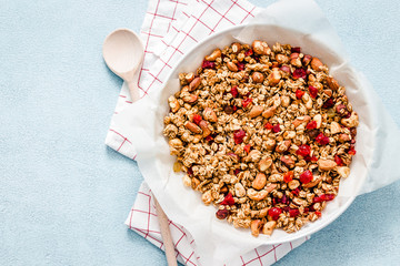 Sea salt cinnamon cashew granola on light blue background. Top view, space for text. 