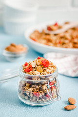 Coconut pecan granola on light blue background. Selective focus, copy space.