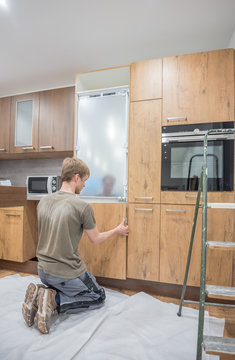 Handwerker baut neue Einbauk&uuml;che auf