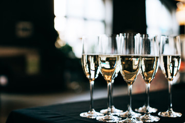 Many glasses of champagne at wedding reception on dark background