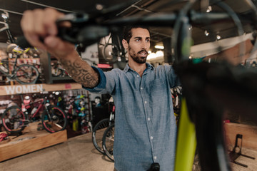 Obraz na płótnie Canvas Worker inspecting a bicycle in workshop