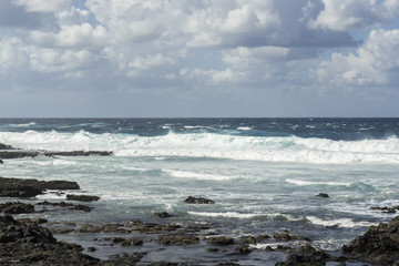 Fototapeta na wymiar Rough turquoise sea with big waves and surf at La Santa, Lanzarote, Canary Islands, Spain