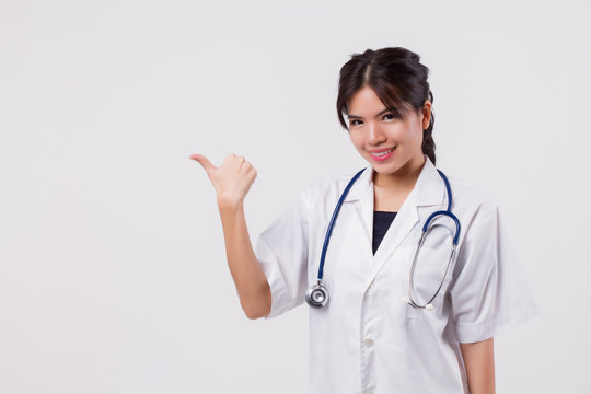woman doctor pointing thumb up gesture, asian female health care worker or nurse point thumb up to blank space