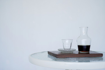 Serving coffee Hario v60 in a jug for smell, wooden. The background is blurred, all white. Side view with copy space