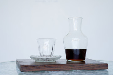Serving coffee Hario v60 in a jug for smell, wooden. The background is blurred, all white. Side view with copy space