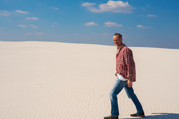 Joyful traveler, man walks along desert
