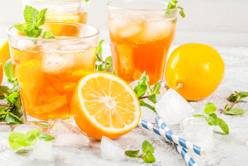Cold summer drink. iced tea with lemon and mint, on grey stone background.  Copy space