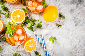 Cold summer drink. iced tea with lemon and mint, on grey stone background.  Copy space top view