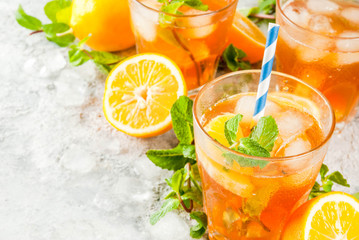 Cold summer drink. iced tea with lemon and mint, on grey stone background.  Copy space