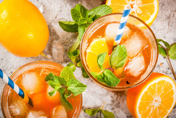 Cold summer drink. iced tea with lemon and mint, on grey stone background.  Copy space top view