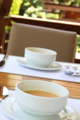 Two plates of hot soup on a summer terrace