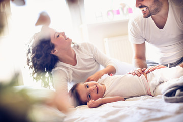 Obraz premium Little girl with her parents playing at morning.