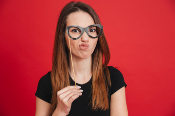 Portrait of a funny girl grimacing with fake eyeglasses