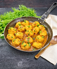 Meatballs in pan with sauce on black board